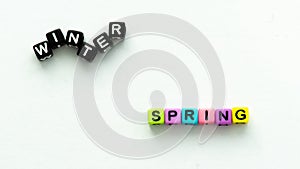 Spring coming and changing winter. Spring concept. Colorful letter beads on white background.