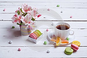 Spring composition: a cup of tea, almond cookies, bright flowers