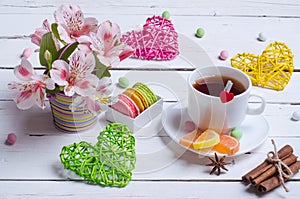 Spring composition: a cup of tea, almond cookies, bright flowers