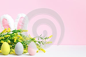 Spring composition. Easter eggs rabbit ears flowering branch on the table