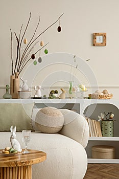 Spring composition of easter living room interior with mock up poster frame, modern sideboard, coffee table easter eggs, round