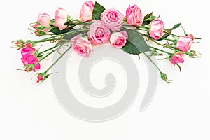 Spring composition with pink roses on white background. Top view. Flat lay. Floral frame of flowers, copy space