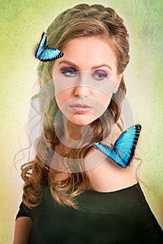 Spring concept of a blonde woman with a blue butterfly on her ha