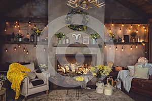 Spring cosy interior of country house with fireplace, flashlights, mimosa flowers and beautiful decorations. Yellow color in