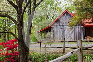 Spring in the country with a red-roofed barn and trees.