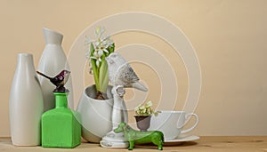 Spring cozy home decor: white vases, white hyacinths, cup and saucer and bird figurines
