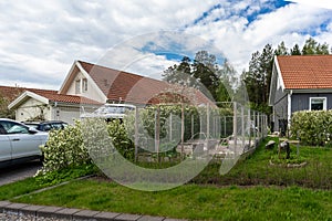 Spring day in the village. Small vegetable garden with beds and first plantings. Wooden houses, villas, cottages with tiled roofs