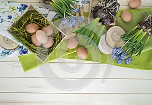 Spring decorative composition. Flowers in a basket and pots of hyacinth, muscari, narcissus. Wooden background.