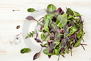 Spring detox Salad mix with arugula, beetroot, spinach and sprouts on bright wooden board over white background, top