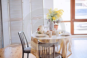 Spring, Easter interior in Scandinavian style. Rustic Living room with bright wardrobe yellow mimosa