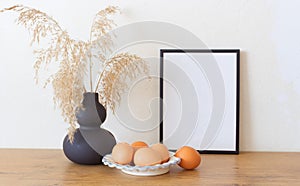 Spring, Easter still life. Empty picture frame mockups. Linen tablecloth, hen eggs. Reed grasses in a ceramic jug