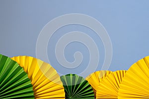 Spring, easter, summer banner. Decor pattern paper fan on blue background. Yellow green fans.