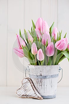 Spring easter tulips in bucket on white vintage background.