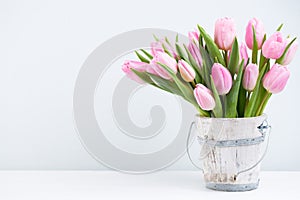 Spring easter tulips in bucket on white vintage background.