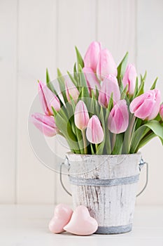 Spring easter tulips in bucket on white vintage background.