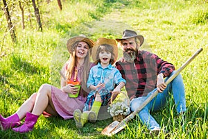 Spring farm work. Happy family rest on green grass. Hobby farm. Farm tourism or agritourism. Gardening and homesteading