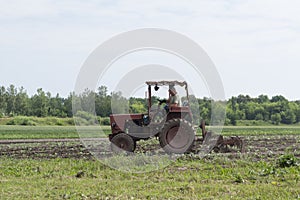 Spring field work. Ukraine. A man on a tractor cultivates the land for the sowing of agrotechnical plants.