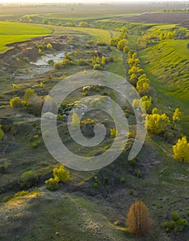 Spring fields, meadows, ravines at sunset from the quadrocopter