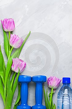 Spring flatlay sports composition with blue dumbbells and purple