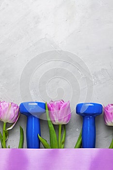 Spring flatlay sports composition with blue dumbbells and purple