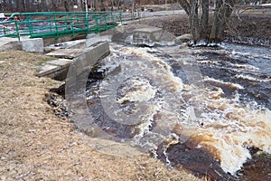 Spring flood. Rushing water in the river. Dark ferrous water rushes in the stream. Karelia, Lososinka River in spring