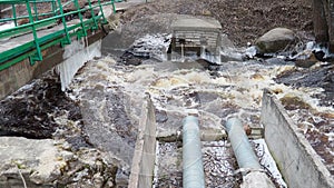 Spring flood. Rushing water in the river. Dark ferrous water rushes in the stream. Karelia, Lososinka River in spring