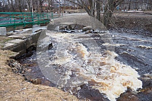 Spring flood. Rushing water in the river. Dark ferrous water rushes in the stream. Karelia, Lososinka River in spring