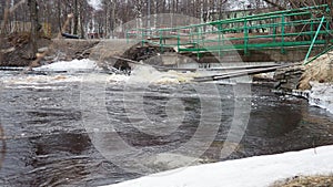 Spring flood. Rushing water in the river. Dark ferrous water rushes in the stream. Karelia, Lososinka River in spring