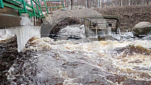 Spring flood. Rushing water in the river. Dark ferrous water rushes in the stream. Karelia, Lososinka River in spring