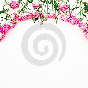 Spring floral frame made of pink roses, buds and leaves on white background. Flat lay, Top view.