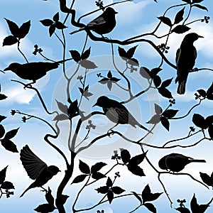 Spring floral seamless wallpaper with birds on branches over blue sky
