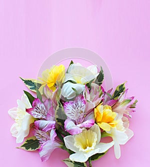 Spring flower arrangement. Pink astromeria and yellow tulips on a pink background. photo