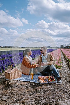 Spring flower season in the Netherlands, couple having a picnic during sprin in the bulb region by Lisse with Hyacinth