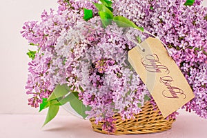 Spring flowers beautiful pink  blue lilac branch in basket. Happy birthday text