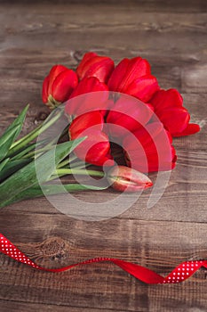 Spring flowers. Bouquet of Red tulips on brown wooden background. Mother`s Day and Valentines Day background