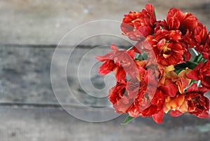 Spring flowers. Bouquet of Red tulips on brown wooden background. Mother's Day and Valentines Day background