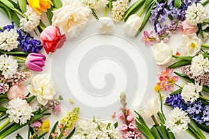 Spring flowers frame made of tulips, daffodils, crocuses, hyacinths, lilacs, cherry blossoms, azaleas on white