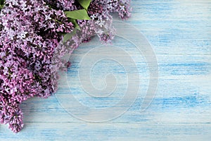 Spring flowers. Frame of twigs of blooming lilac on a blue wooden table. top view. place for text