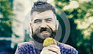 Spring flowers. Man with beard and mustache on happy face holds bouquet of dandelions. Bearded man holds yellow