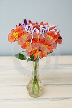 Spring Flowers Orange alstromeria flwoers in Glass Vase Wooden Background