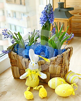 Spring flowers in a small basket and easter rabbit photo