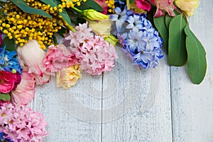 Spring flowers on wood background. Summer blooming border on a w