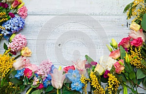 Spring flowers on wood background. Summer blooming border on a w