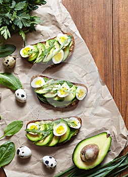 Spring food. Sandwiches with avocado, spinach, guacamole and quail eggs on parchment. Low carbohydrate diet of organic