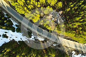 In the spring forest top view Snow melts on the side of the road and between the trees