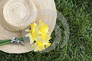 Spring forward, springtime, easter concept, yellow daffodil flowers with a straw hat