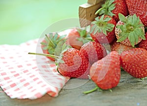 Spring fruits, strawberries in wooden bucket on a vintage wooden table