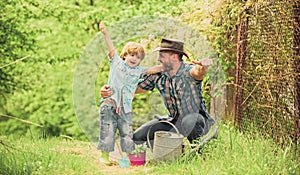 Spring garden. Dad teaching little son care plants. Personal example. Little helper in garden. Planting flowers. Growing