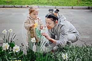 Spring Gardening activities for toddler kids. Senior woman grandmother and little toddler girl granddaughter watering