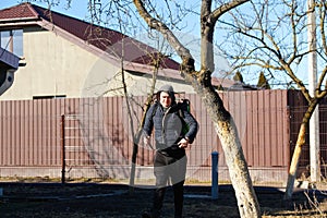 Spring gardening. Defocus farmer man spraying tree with manual pesticide sprayer against insects in spring garden